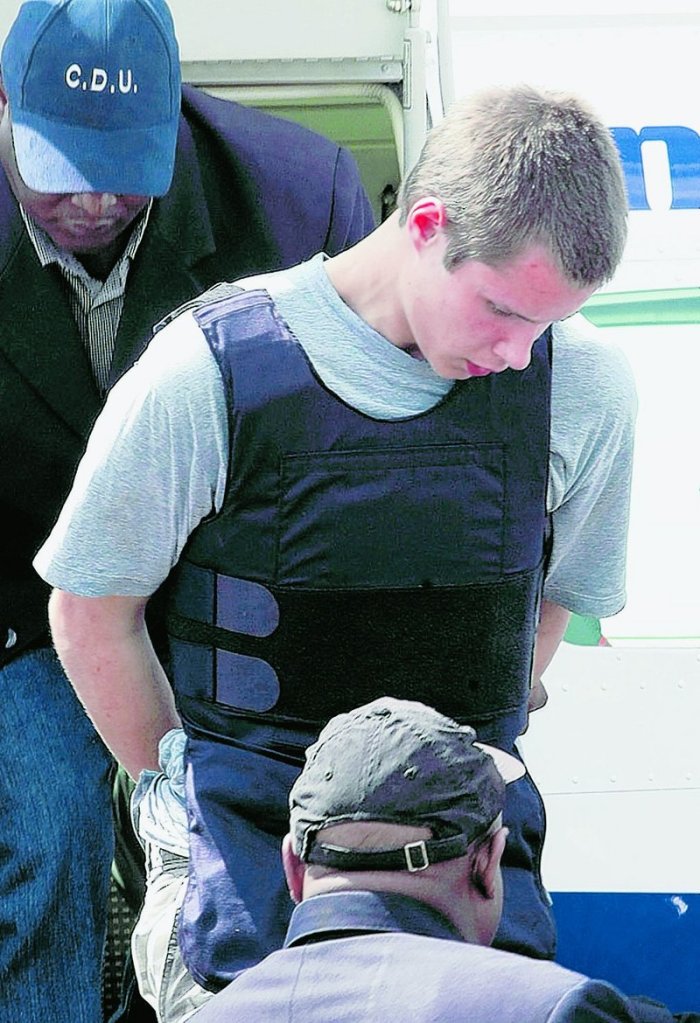 Colton Harris-Moore is escorted by police as he arrives in Nassau, Bahamas, following his arrest Sunday.