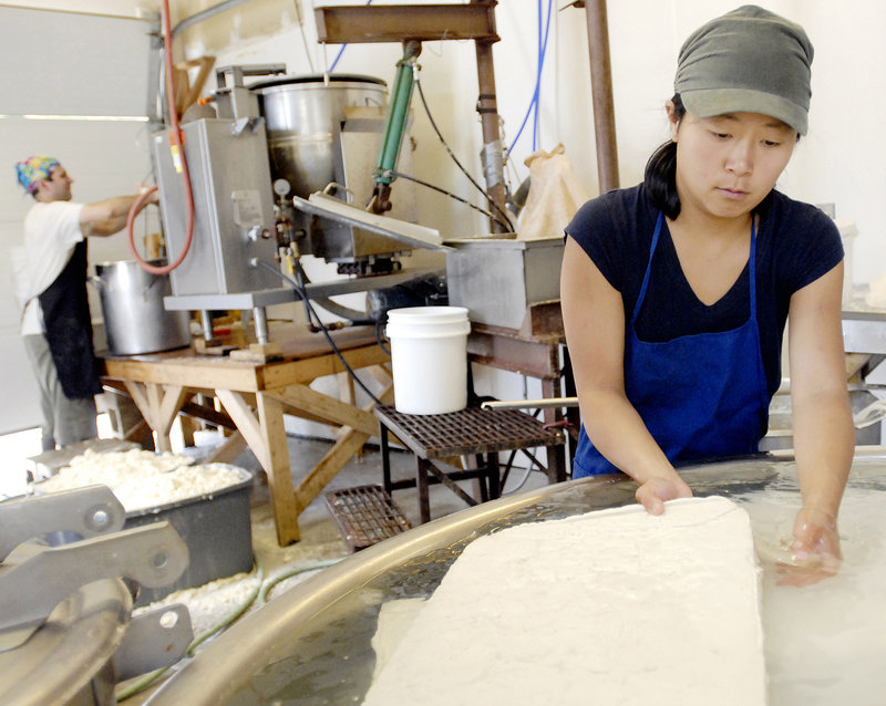 Maho Hisakawa removes a finished tofu block from the cooling tank. Heiwa Tofu can make nearly 1,000 pounds of tofu a week. The tofu is distributed in Maine and surrounding areas.