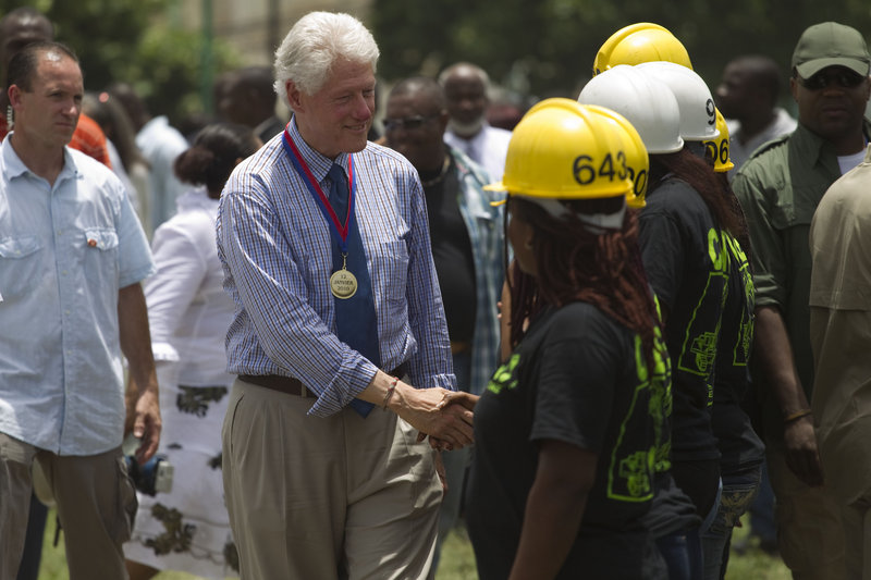 Bill Clinton, U.N. special envoy for Haiti, center, greets reconstruction workers during a service for the six-month anniversary of the Jan. 12 earthquake in Port-au-Prince.