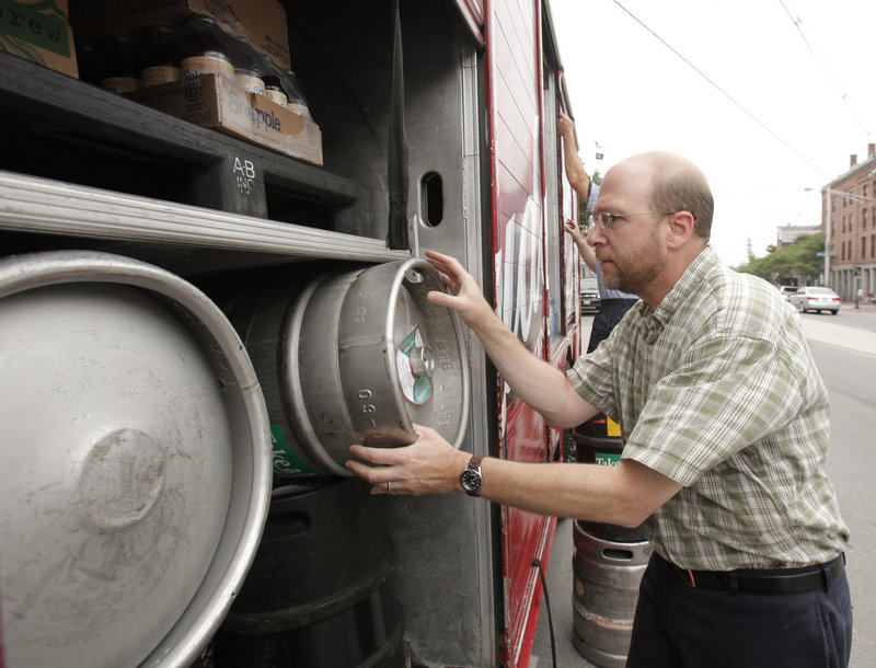 Reporter Ray Routhier puts an empty keg back on a National Distributors truck while delivering beer and wine in Portland.