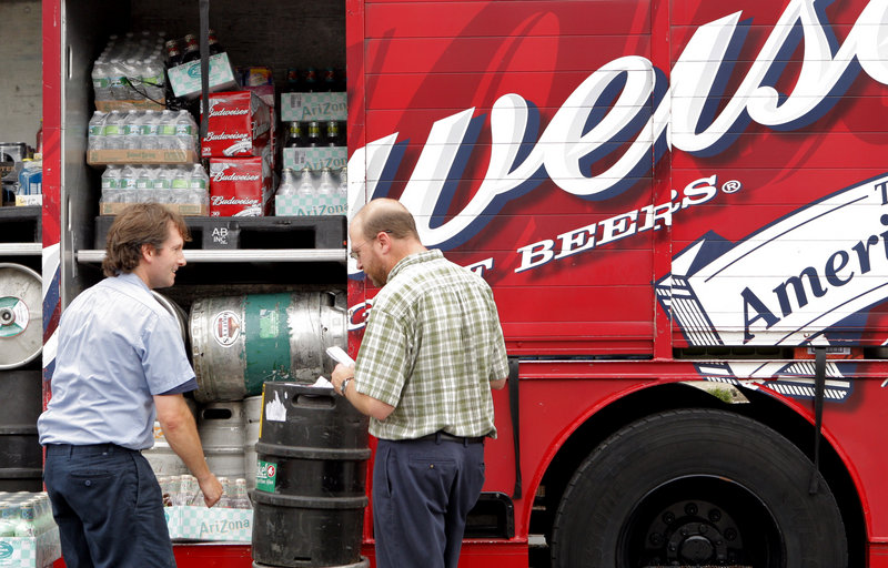 Ray Routhier, right, works with Steve Gale of National Distributors delivering beer and wine to restaurants on Commercial Street in Portland last week. Gale starts work at 6:30 a.m.