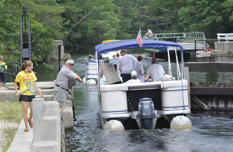 Inspector Kelly Baldwin checks a boat for milfoil Tuesday as it passes through the Songo Locks in Naples. Inspectors will urge boaters to stay out of the Songo River to prevent milfoil from re-entering Brandy Pond and waters to the north.