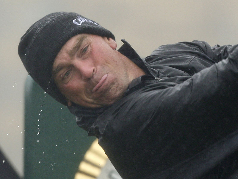 Water drips off Thomas Bjorn of Denmark as he hits a shot during a practice round on the Old Course at St. Andrews, Scotland, in preparation for the British Open, which begins today.