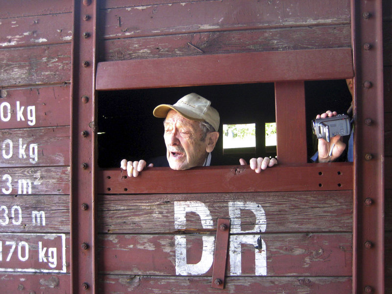 Adolek Kohn, 89, looks out the window of a train freight car that used to transport people to the Auschwitz death camp in Poland in this image taken during the making of a video clip that became controversial on the Internet.