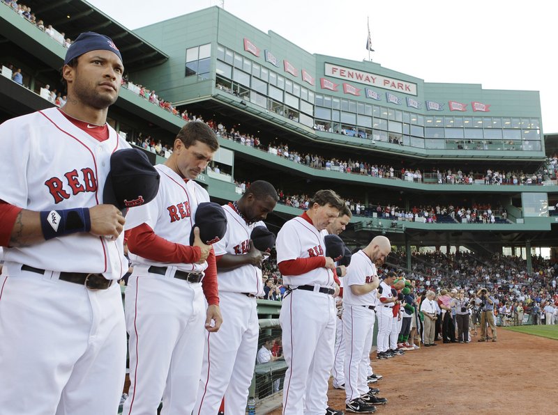 Members of the Boston Red Sox pause for a moment of silence before Thursday's game to honor George Steinbrenner, the Yankees' owner, and Bob Sheppard, the Yankees' public address announcer. Both died this week.