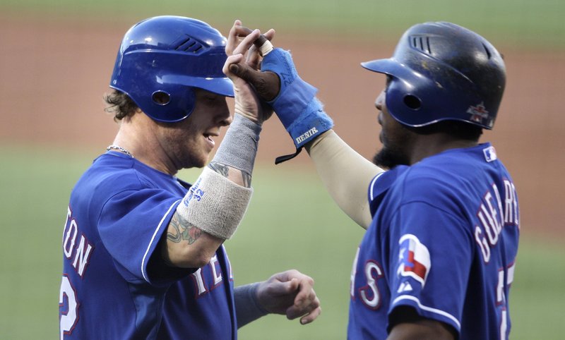 Josh Hamilton, left, and Vladimir Guerrero exchange welcomes Thursday night after both scored for the Texas Rangers on a single by Nelson Cruz in the first inning. Texas beat the Boston Red Sox at Fenway Park, 7-2.