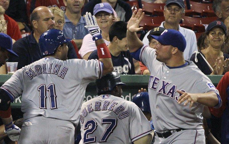 Texas’ Bengie Molina, left, is congratulated by starting pitcher Colby Lewis after Molina hit a grand slam off Fernando Cabrera in a five-run fifth inning.