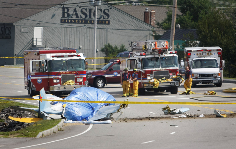 Debris from a crashed Yak-52 training aircraft litters Western Avenue in South Portland on Saturday across from Staples plaza. Two people aboard the plane, one from Brunswick and the other from Portland, were killed in the crash.