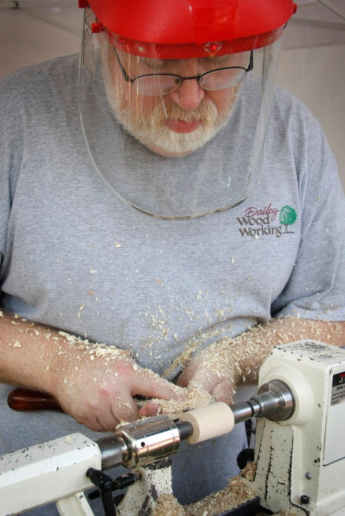 Craftsman Kim Dailey of Dailey Woodworking creates a bottle stopper with wood from Herbie, the famous Yarmouth elm tree, at the Yarmouth Clam Festival on Saturday.