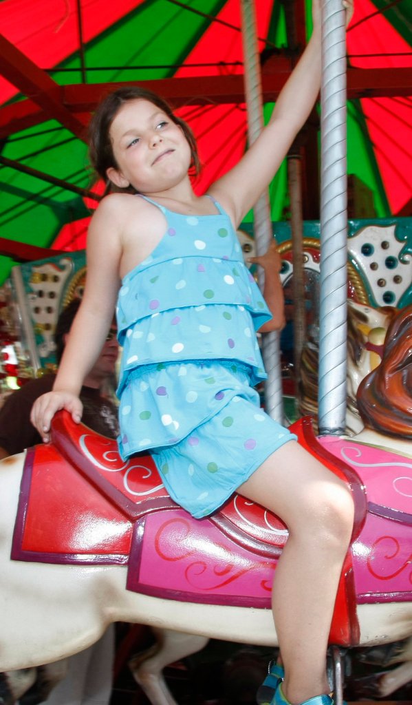 Alonna Hanneman, 7, of Kennebunk enjoys a merry-go-round ride, one of the many fun things to do at the festival.