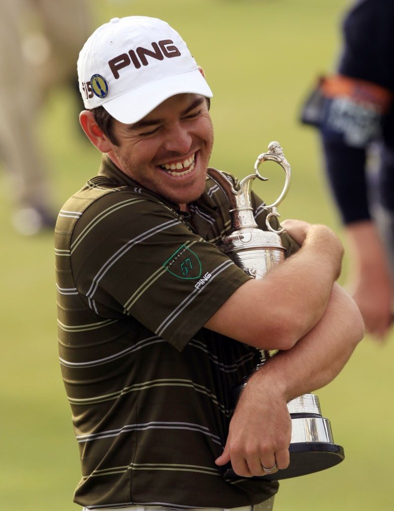 Louis Oosthuizen of South Africa wraps his arms around the silver claret jug that is the oldest of golf’s major trophies after winning the British Open on Sunday.