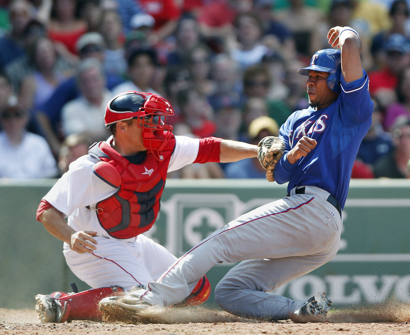 Elvis Andrus gets his foot on the plate as Red Sox catcher Kevin Cash applies the tag in the eighth inning Sunday at Fenway Park. Andrus was called safe, and the Rangers went on to a 4-2 victory.
