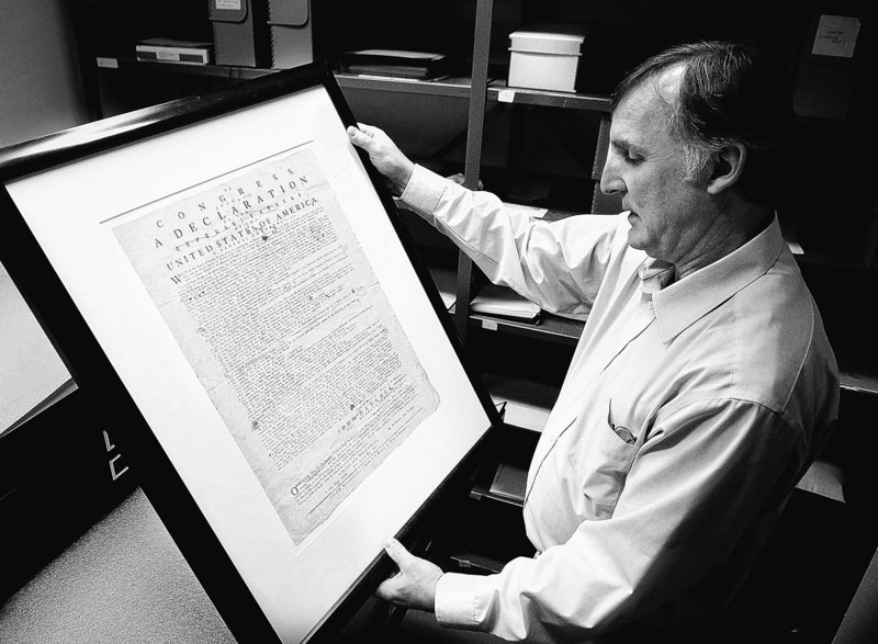 Archivist Jeff Brown examines one of Maine's copies of the Declaration of Independence made in 1776.