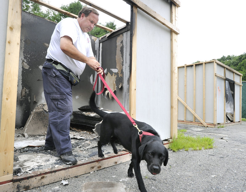 Investigator Rick Shepard of the state Fire Marshal’s Office and his dog Shasta work a staged fire scene Tuesday as they and other arson teams train at a facility in Yarmouth.