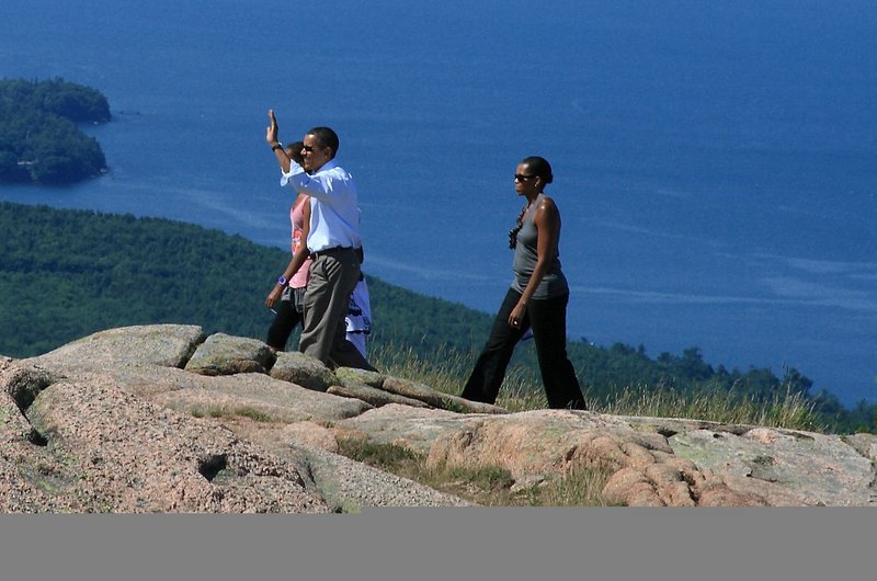 President Obama waves as he and first lady Michelle Obama and their daughters take in Cadillac Mountain in Acadia National Park last weekend.