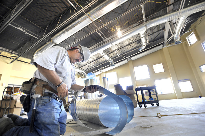 Raymond Roy cuts ductwork for the cafeteria of the school, which is expected to be completed by Thanksgiving.