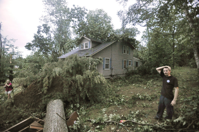 Kyle Lewis assesses the damage at his home on Fort Hill Road (Route 114) in Gorham after a severe storm raked the area. His aunt, Heather Coppola, said they were eating dinner when the sky turned black and they saw a funnel cloud forming.