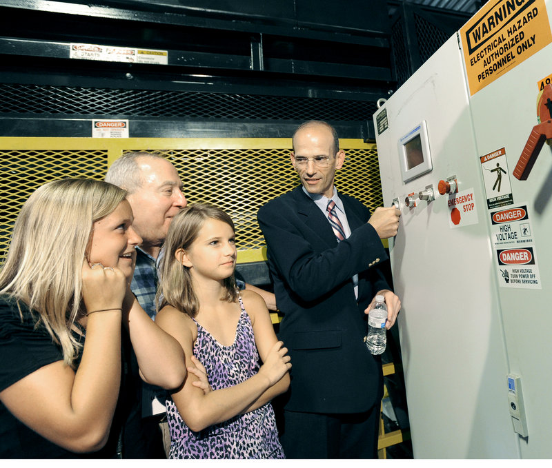 Gov. John Baldacci presses a button to start the machinery for CLYNK’s new beverage container sorting system on Wednesday. From left, Emily Michaud, 12, and Peter Lunder from Scarborough, and Dana Goldy, 11, from Westboro, Mass., look on.
