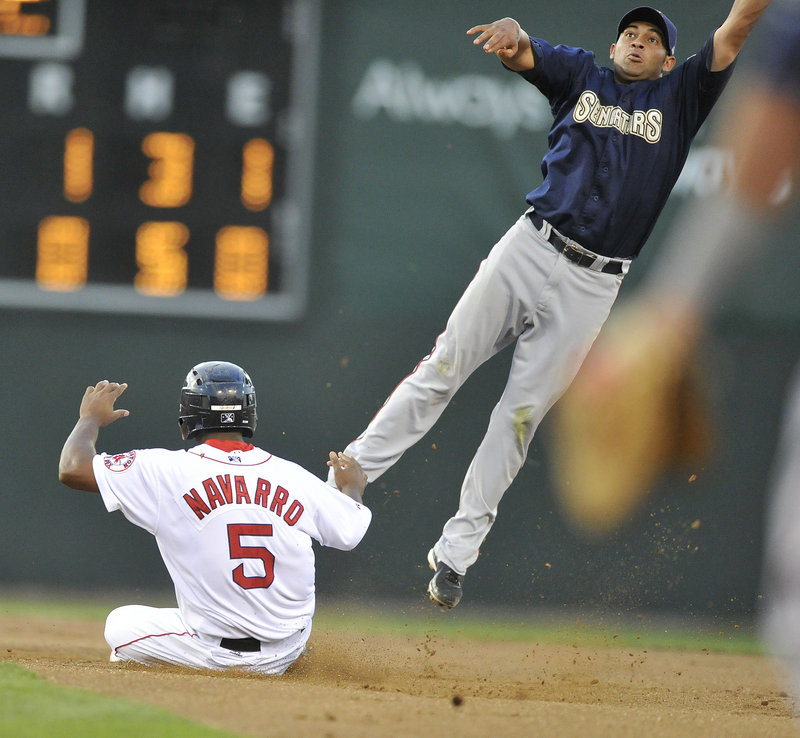 Yamaico Navarro of the Portland Sea Dogs slides into second with a stolen base as Ofilio Castro of Harrisburg attempts to take down a throw that landed in center field.