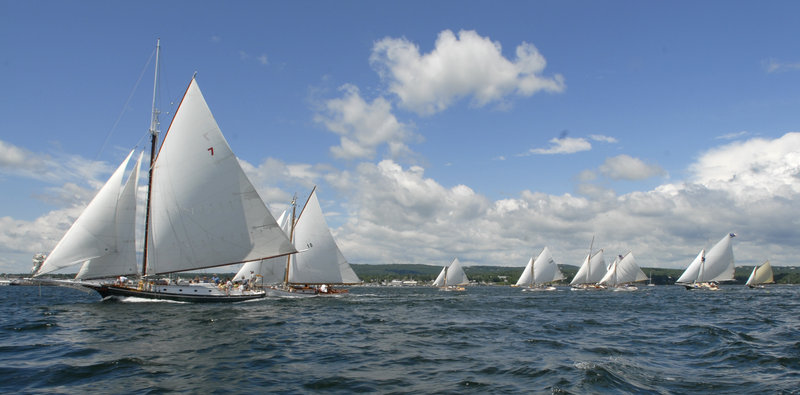 About two dozen sailboats race across the starting line during the Friendship Sloop Society's 50th annual Homecoming and Rendezvous race around Rockland Harbor on Thursday.