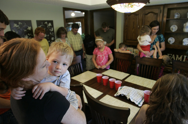 Gabriel Hambleton is held by his mother, Gina, during prayer at a house church in Dallas. Nine percent of American Protestants attend only home services, a 2009 survey found.