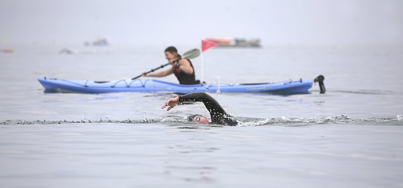 With a kayaker for company, Matthew Libby of Freeport strokes toward the finish of the Peaks to Portland open-water swim on Saturday.