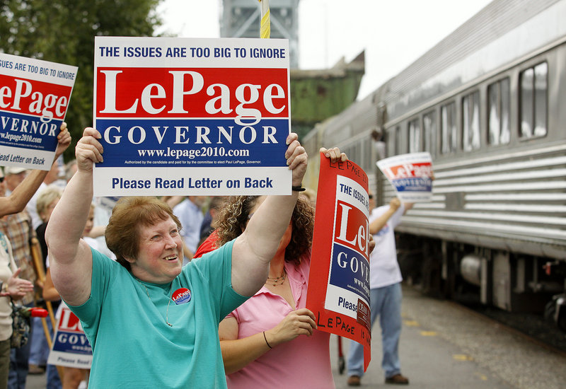 Ruthe Pagurko of Bath holds up a sign as candidate for governor Paul LePage stops in Bath on a train tour.