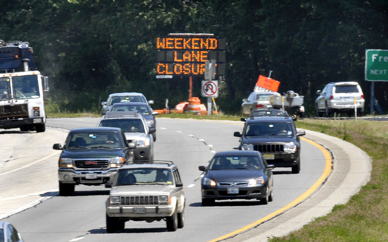 Traffic in the southbound lanes passes a sign Monday warning northbound motorists on Interstate 295 in Yarmouth about the weekend lane closing. This past weekend there were backups of up to six miles and hour-long delays.