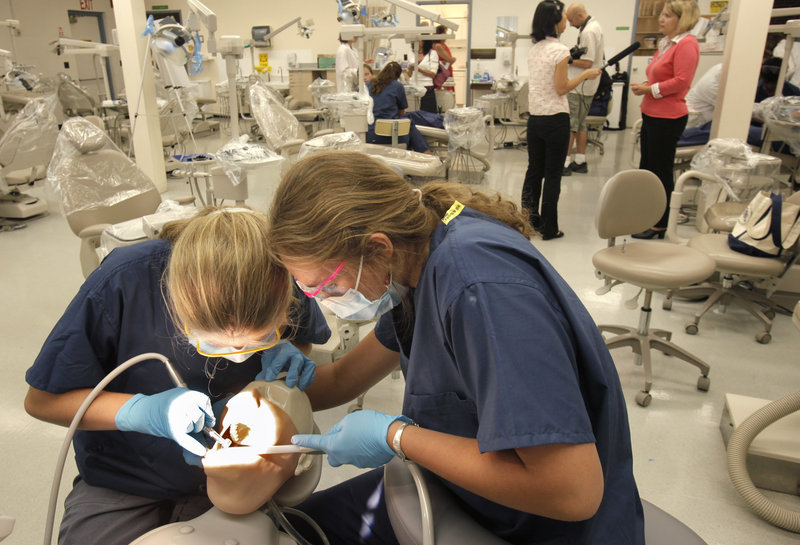 Students Devin Ward, left, and Casey Thornton team up at a patient simulator. The UNE clinic was created to spur interest in dental careers, and hopefully boost Maine’s professional ranks.