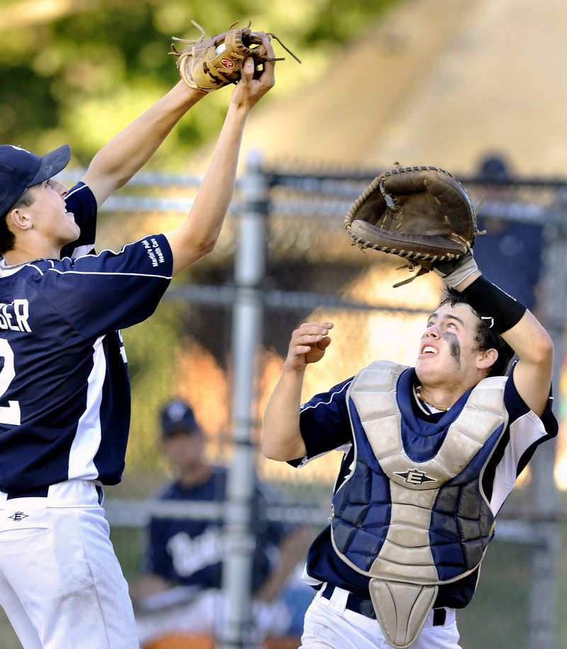 Portland pitcher Caleb Fraser, left, pulls down a pop foul in front of catcher Nick Volger during the Babe Ruth 15-year-old state championship Monday.