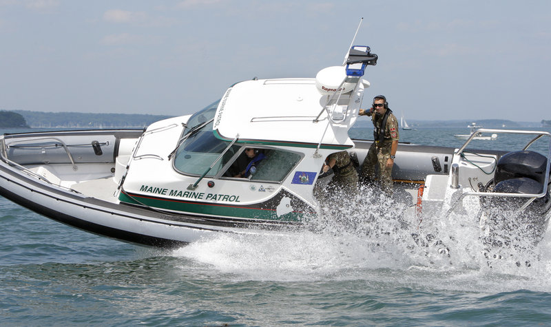 Montenegrin navy members hold on as a Maine Marine Patrol boat takes a tight turn during training on Casco Bay on Wednesday.
