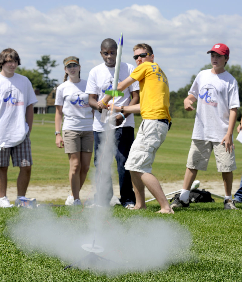Damien Kayamba, 14, of Portland and instructor Ben Ingraham in yellow, both center, launch a rocket at Twin Brook Recreational Area in Cumberland on Friday. Ten students, ages 10 to 14, attended the city-run Aviation Career Exploration Academy.