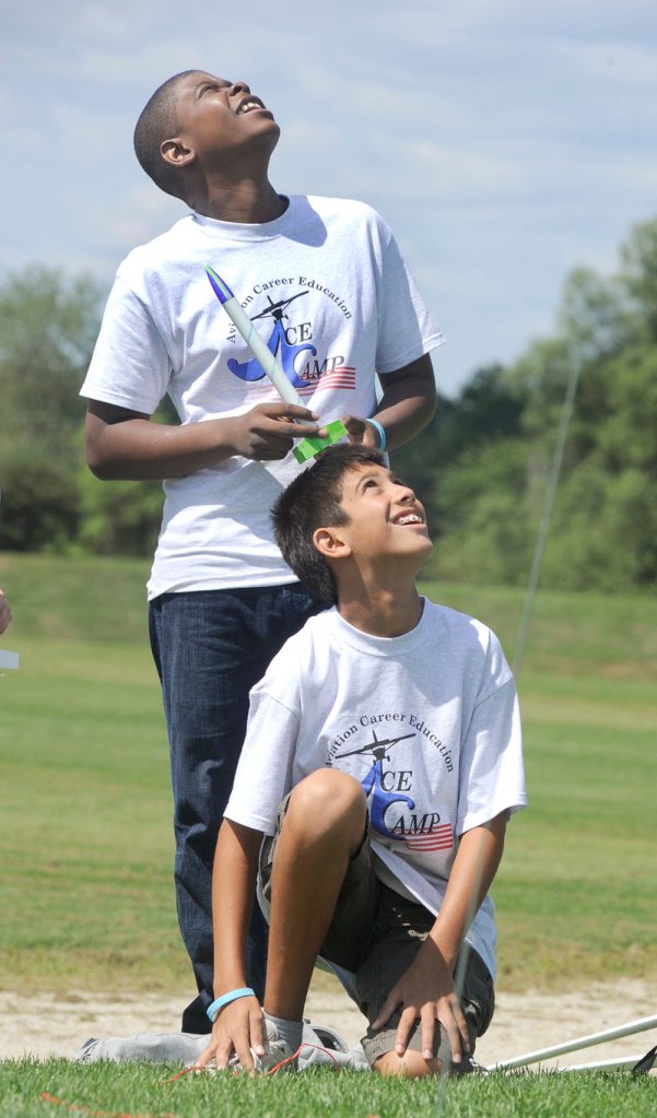 Trystan Bates, 12, of Gorham, kneeling, watches his rocket soar as Damien Kayamba waits his turn. The ACE Academy program was established by the FAA to generate interest in aviation.
