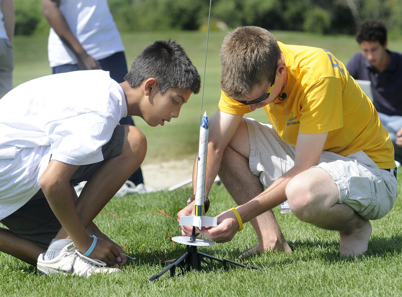 Trystan Bates, 12, of Gorham, left, watches as instructor Ben Ingraham prepares to launch a rocket at Twin Brook Recreation Area in Cumberland on Friday. “This camp is like one big field trip,” said Adam Godfrey, 11, of Yarmouth.