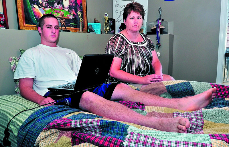 Nathan Natole, shown with his mother, Pam, uses his laptop at their home in Oakland. He was recharging the computer in his bedroom when lightning struck nearby on July 21, causing injuries to his leg and head and leading to a seizure.