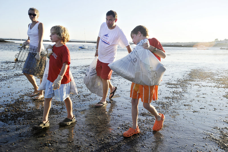 The Wood family – Seana, left, and Roger, second from right, and their sons Oliver and Aidan – participate in the Kennebunk Beach Improvement Association's annual cleanup of Kennebunk Beach on Friday evening. About 200 volunteers joined in.