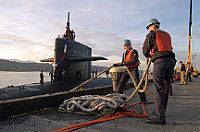 Sailors tend mooring lines as the ballistic-missile submarine USS Maine (SSBN 741) Blue crew returns from a regularly scheduled patrol Oct. 21.