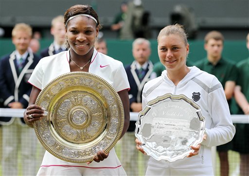 Serena Williams, left, of the United States holds her winners trophy as she stands next to runnerup Russia's Vera Zvonareva after their women's singles final at the All England Lawn Tennis Championships at Wimbledon, Saturday, July 3, 2010. (AP Photo/Alastair Grant)