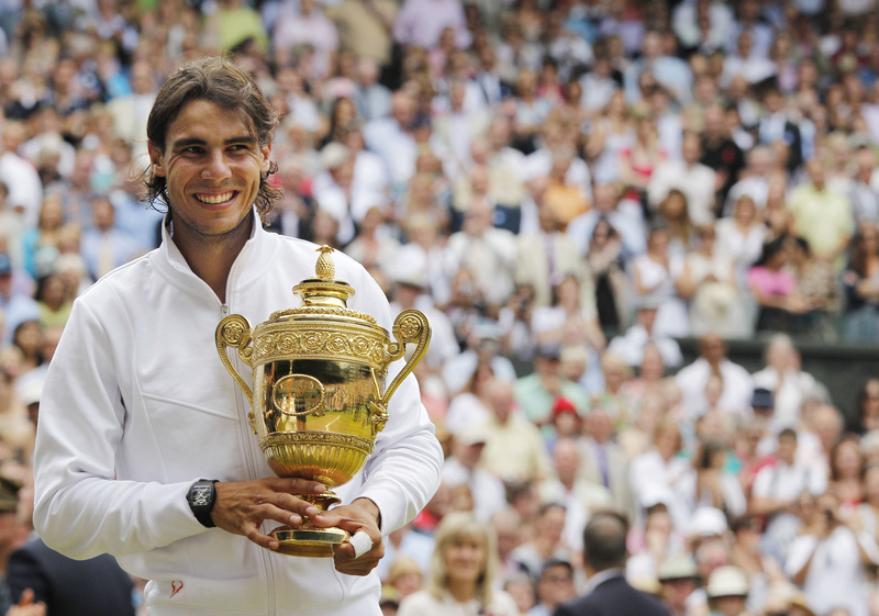 Rafael Nadal smiles as he holds his trophy after defeating Tomas Berdych of the Czech Republic in the men's singles final at the All England Lawn Tennis Championships at Wimbledon today.