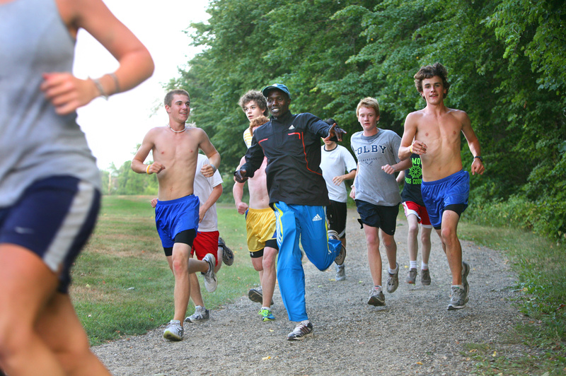 Tim Greenway Tim Greenway/Staff Photographer Wilson Chebet of Kenya, middle, who finished third in this year’s Beach to Beacon 10K road race, runs with Falmouth High School students and members of the Portland Recreation Track Club on the trail around Mackworth Island in Falmouth on Tuesday.