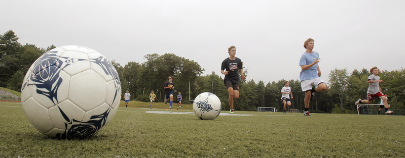Candidates for the Yarmouth boys' soccer team run sprints during their opening day of practice.