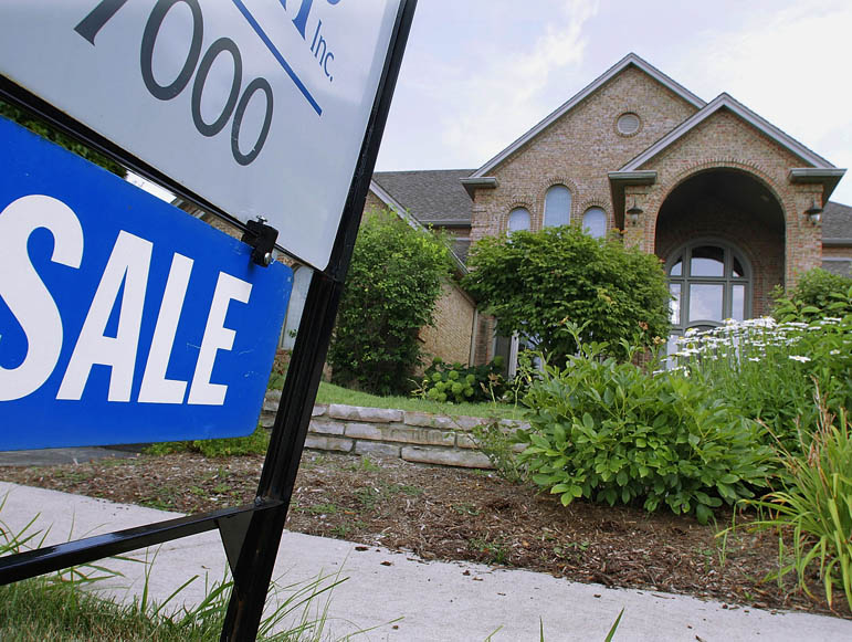A "For Sale" sign is displayed outside a home in Springfield, Ill. Despite the lowest mortgage rates in decades, homes are quickly returning to their prewar status as places to live rather than sources of wealth.