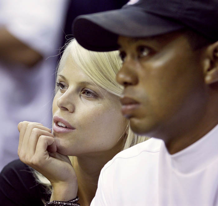 In this June 2009 photo, Elin Nordegren talks to her then-husband, golfer Tiger Woods during an NBA basketball game in Orlando, Fla. "How could I not have known anything?" Nordegren told People magazine.