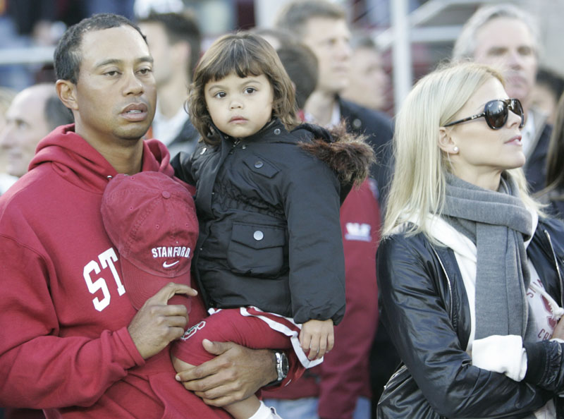 In this photo taken Nov. 31, 2009, Tiger Woods, his daughter Sam and wife Elin Nordegren attend a college football game in Stanford, Calif.