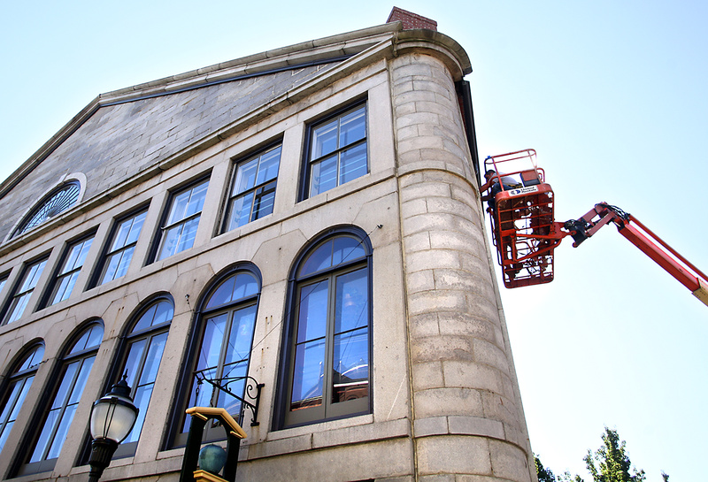 Mark Dussault and Michael Gombos of D & G Restoration repair a window Monday in the Mariner’s Church on Fore Street in Portland. The company is repairing water-damaged windows and restoring the exterior of the building, which was built in 1829.