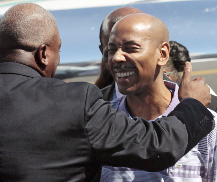 Aijalon Gomes is greeted by family members after arriving with former President Jimmy Carter at Logan International Airport in Boston today.