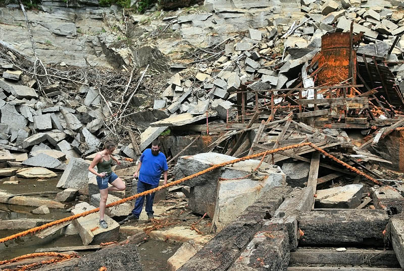 Christine Bruen, left, and Dennis Bruen climb amongst the ruins on the floor of the recently drained Stinchfield Quarry during a tour on Sunday afternoon in Hallowell.