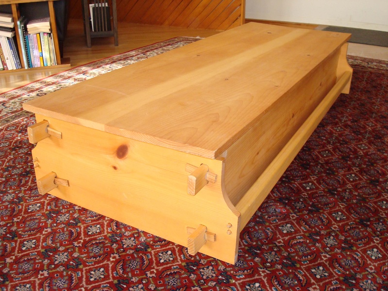 The wedged coffin, made by Chuck Lakin of Waterville, can be stood on end and used as a bookcase, display shelf or a wine rack, or on its back and used as a storage chest and/or coffee table like here.