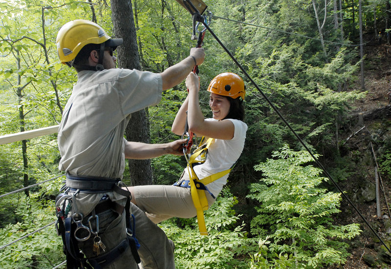 Brian Stack, a lift mechanic at Sunday River, catches Darcy Liberty as she glides onto a ramp. Such forest zip lines have long been popular in other countries.