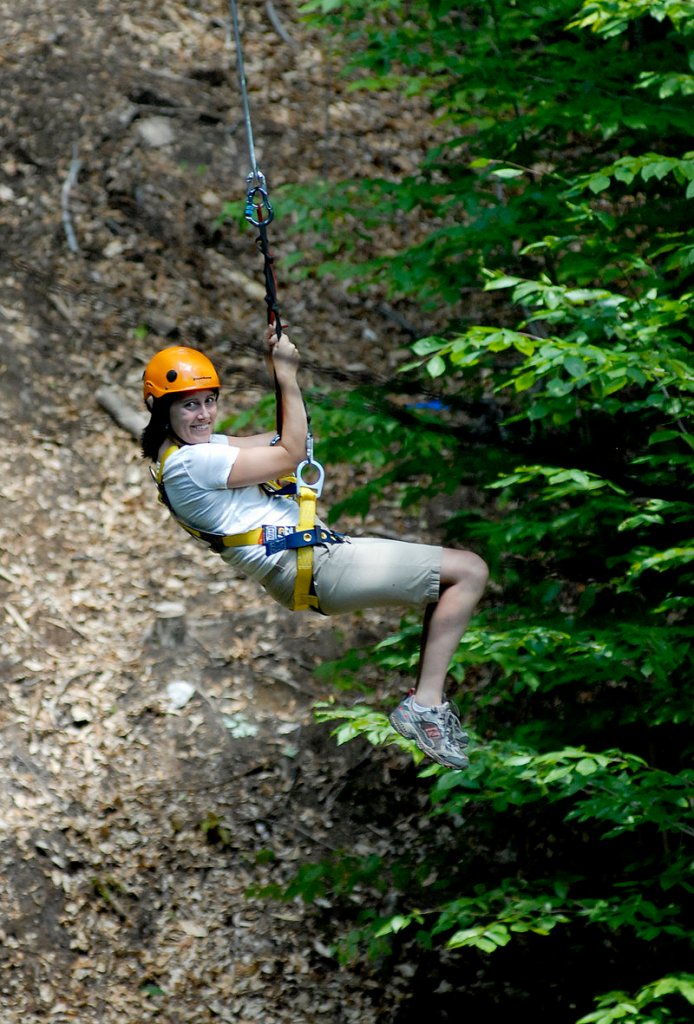 Darcy Liberty, director of communications at Sunday River, zips through an opening in the forest canopy in Newry.